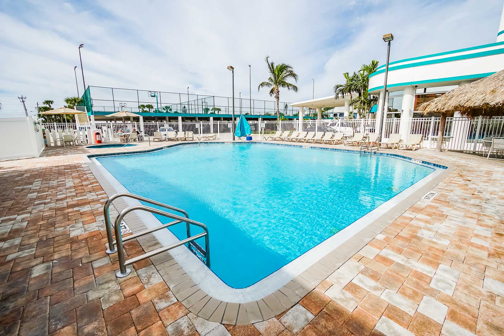 A spacious outdoor swimming pool at VRI's Discovery Beach Resort in Cocoa Beach, Florida.